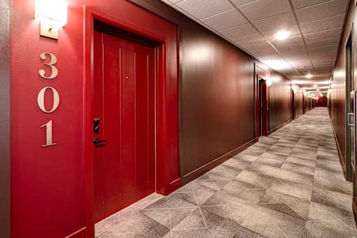 A hallway with red doors and a number 301 on the wall. at 985 High Apartments, Columbus