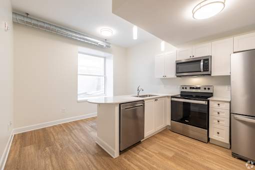 a renovated kitchen with white cabinets and stainless steel appliances