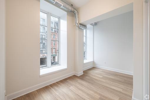 a living room with two windows and a wooden floor