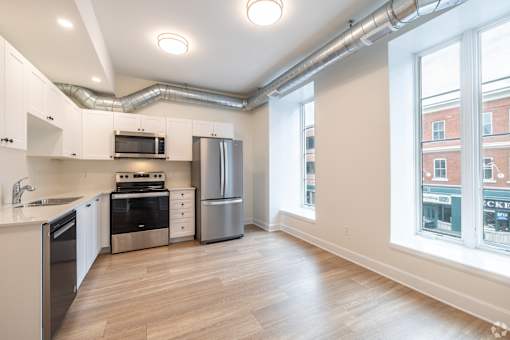 an empty kitchen with stainless steel appliances and a large window