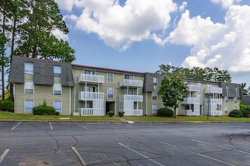 Apartment building with a parking lot in front.