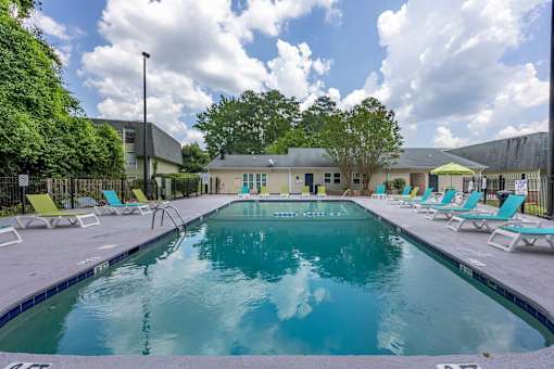 A large outdoor swimming pool surrounded by sun loungers.