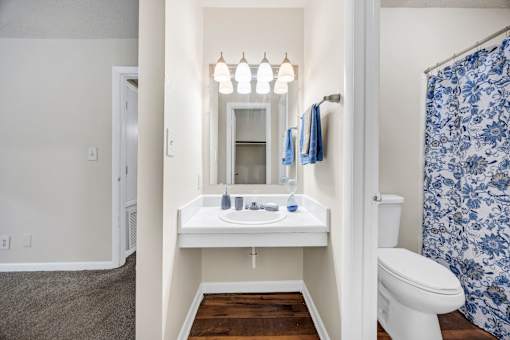A bathroom with a white sink and a toilet.