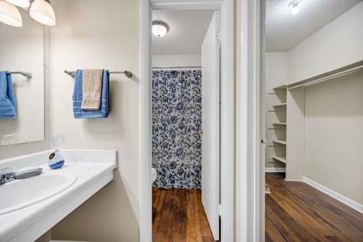 A bathroom with a white sink and a blue and white shower curtain.