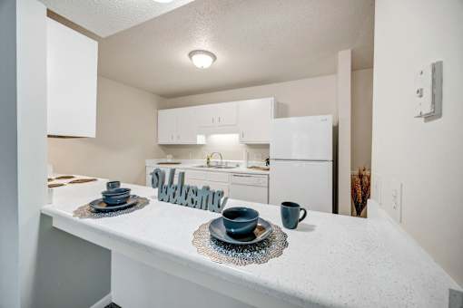 A kitchen with a white countertop and a white refrigerator.