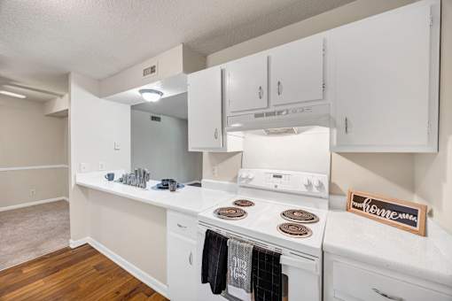 A kitchen with white appliances and cabinets.