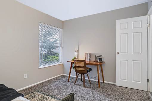 A room with a desk and chair in it.
