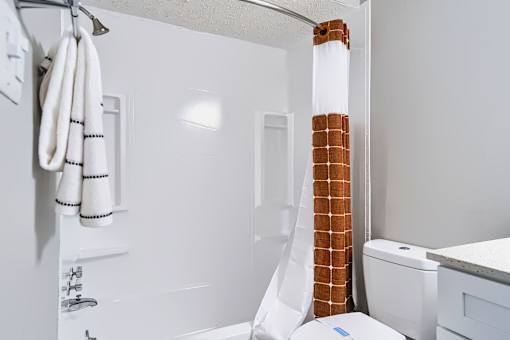 A white bathroom with a towel rack and a toilet.
