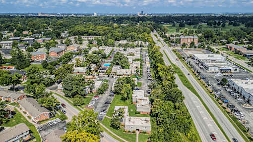 A bird's eye view of a suburban area with houses, trees, and a highway.