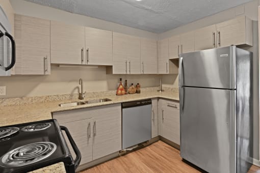 An updated kitchen with white cabinets and granite countertops at Heritage Hill Estates Apartments, Cincinnati, Ohio 45227