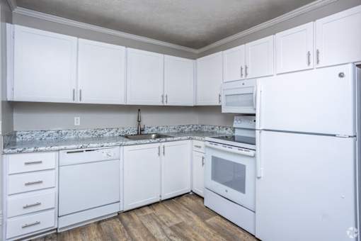 A kitchen with white cabinets and appliances.
