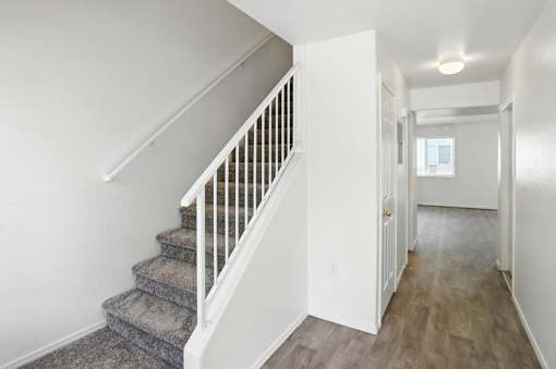 A hallway with a staircase and a door. at Oakstone Apartments, Clearfield