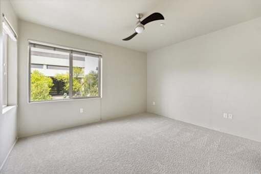 A room with a window and a ceiling fan.