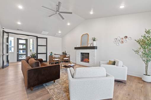 A living room with a fireplace, couches, and a plant.