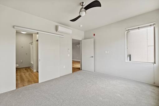 A room with a ceiling fan and a window.