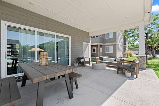 A patio with a table and chairs is set up outside a house.