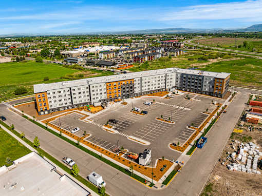 A large parking lot is surrounded by apartment buildings at The Beaumont Apartments, Bozeman, MT