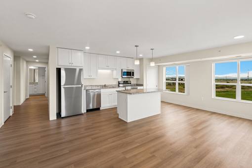 A modern kitchen with white cabinets and stainless steel appliances at The Beaumont Apartments, Bozeman, MT