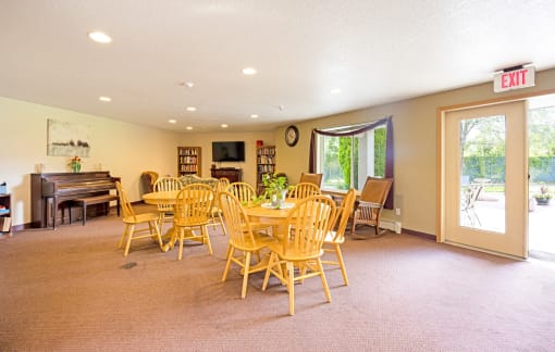 the dining room has a table and chairs and a piano