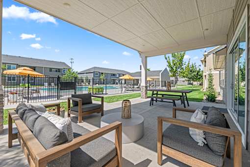 A patio with a white roof and wooden furniture.