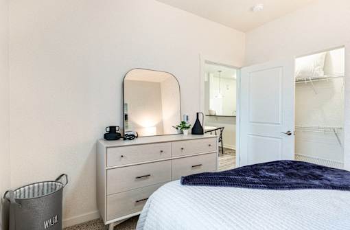 a bedroom with a bed and a dresser with a mirror at Corso Apartments, Missoula, MT