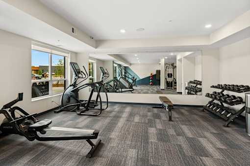 A gym with a treadmill, weights, and exercise equipment at The Beaumont Apartments, Bozeman, 59715