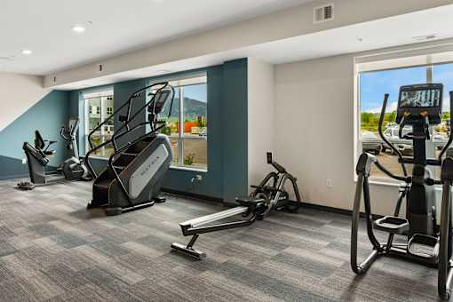 A gym with treadmills, elliptical machines, and a stair climber at The Beaumont Apartments, Montana, 59715