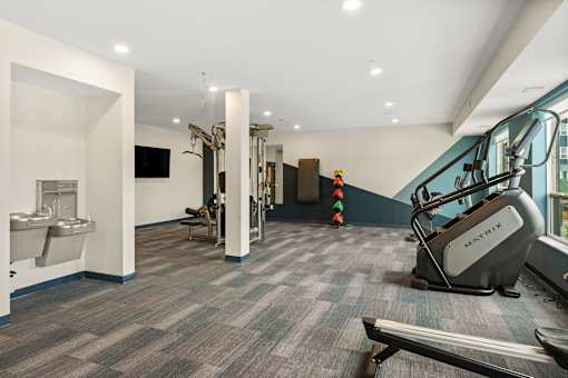 A gym with a variety of equipment including a treadmill, a stationary bike, and a rowing machine at The Beaumont Apartments, Bozeman, Montana 59715