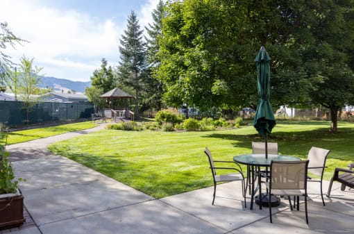 a backyard patio with a table and chairs and a umbrella