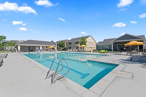 A large outdoor swimming pool with a diving board.