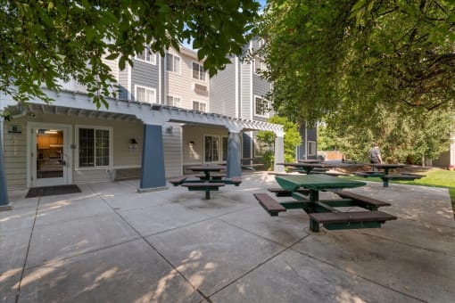 an outside patio with picnic tables and a building