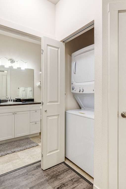 a laundry room with a washer and dryer and a door to the bathroom at Corso Apartments, Missoula, MT