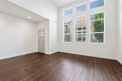 A room with a wooden floor and a door leading to another room. at Verraso Village Apartments, Meridian 83646