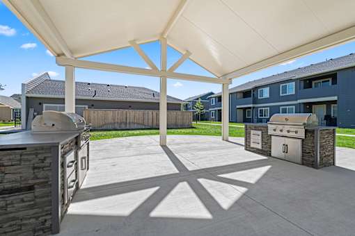 A patio with a white canopy and a stone wall.