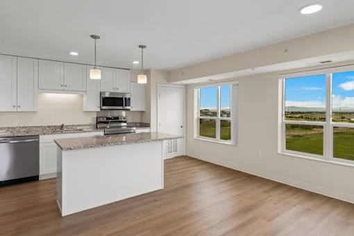 A modern kitchen with a large island and a view of the outdoors at The Beaumont Apartments, Montana