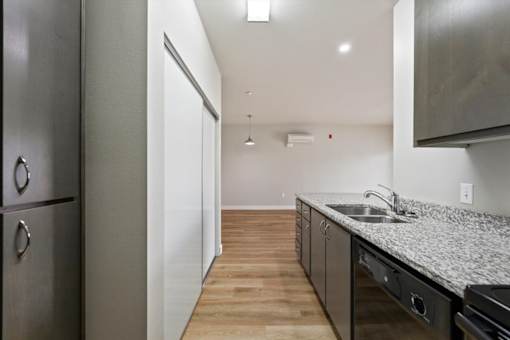 A kitchen with a refrigerator, sink, and cabinets.