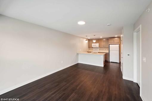 A kitchen with white cabinets and a wooden floor.