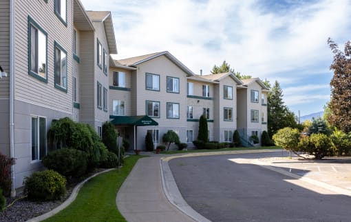the view of a row of apartment buildings with a street in front of them