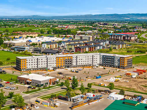 A large building complex with a parking lot in front at The Beaumont Apartments, MT 59715