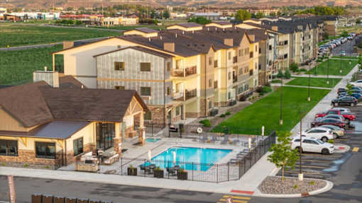 Apartment complex with a pool in the foreground.