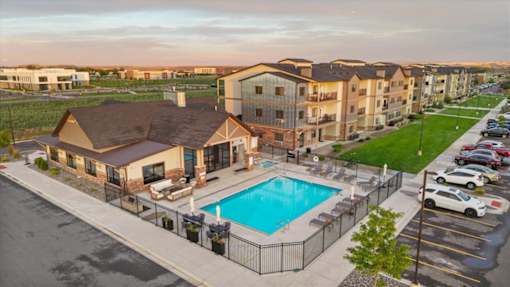 A large apartment complex with a pool in the foreground.