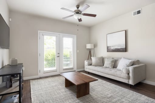 a living room with a couch coffee table and a ceiling fan at The Alloy at Geneva, Vineyard, 84058