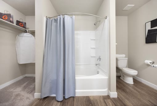 a bathroom with a bathtub and a toilet in a 555 waverly unit at The Alloy at Geneva, Vineyard, Utah