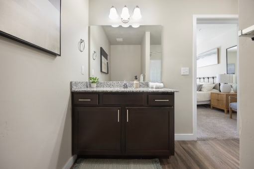 a bathroom with dark cabinets and granite countertops at The Alloy at Geneva, Vineyard, Utah