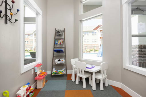 a play room with a table and chairs and a ladder with toys at The Alloy at Geneva, Vineyard, UT, 84058