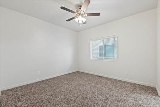 A room with a ceiling fan and a window with blinds. at Verraso Village Apartments, Meridian, ID, 83646