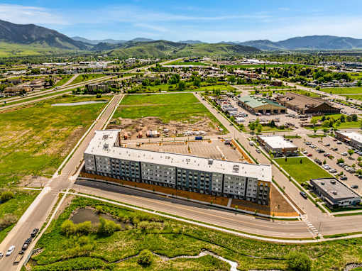 A large building with a parking lot in front of it at The Beaumont Apartments, Bozeman, 59715