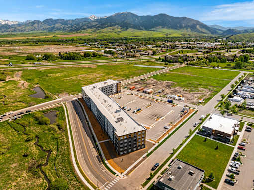 A large building with a parking lot in front of it at The Beaumont Apartments, Bozeman