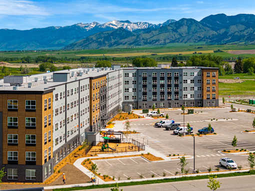 A large parking lot in front of a multi-story building at The Beaumont Apartments, Bozeman, Montana 59715