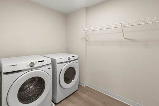 Two white front loading washing machines in a laundry room at The Beaumont Apartments, MT 59715